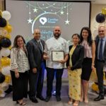 Staff takes a photo with recipient of Volunteer award