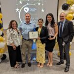 Staff takes a photo with recipient of Volunteer award