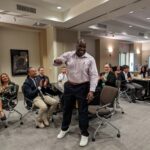 Attendees cheering for a volunteer recipient who won a certificate