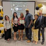 Staff takes a photo with recipient of Volunteer award