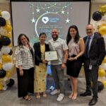 Staff takes a photo with recipient of Volunteer award