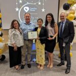 Staff takes a photo with recipient of Volunteer award