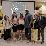 Staff takes a photo with recipient of Volunteer of The Year award