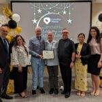 Staff takes a photo with recipient of Volunteer award