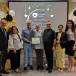Staff takes a photo with recipient of Volunteer award