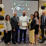 Staff takes a photo with recipient of Volunteer award
