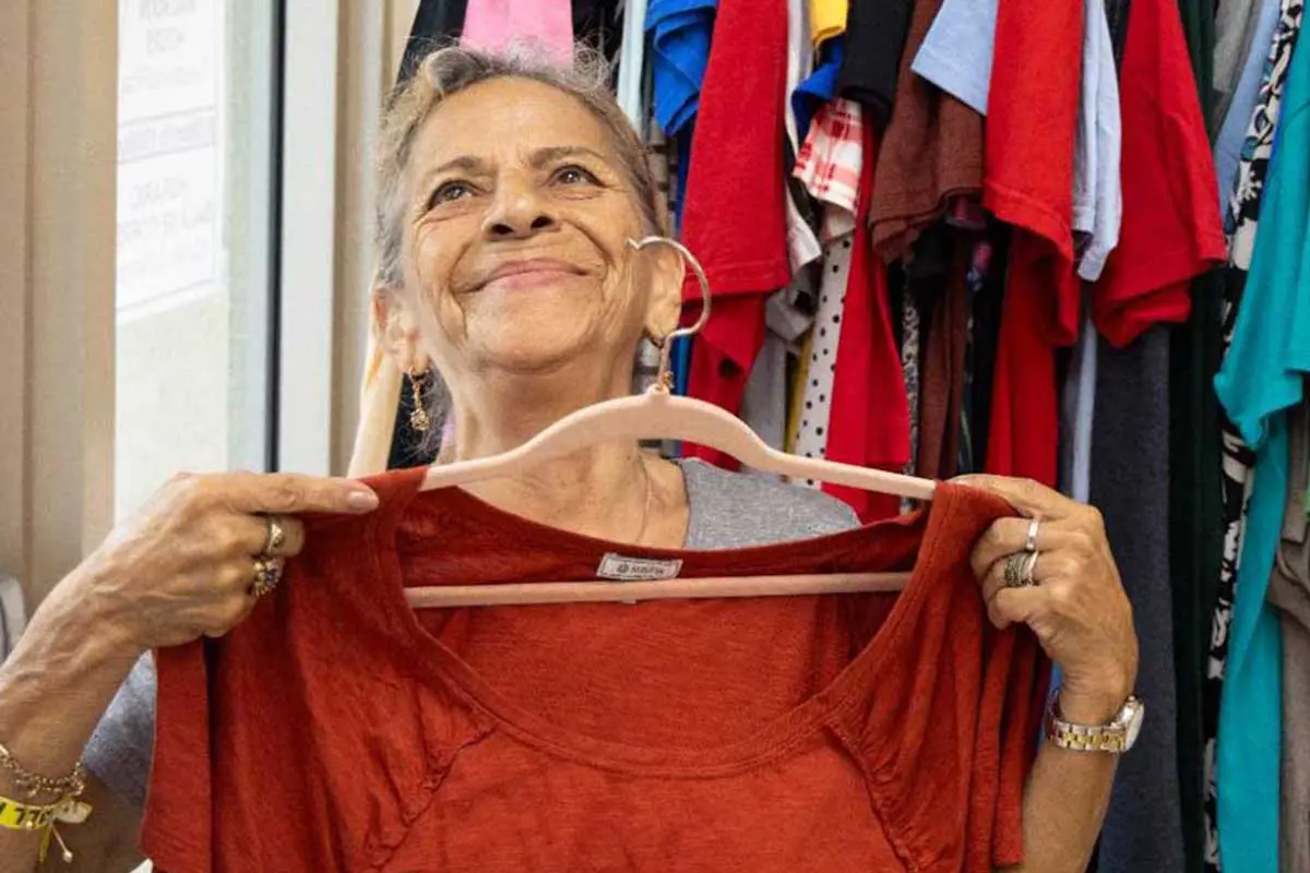 donated-clothing woman selects a red blouse from donated clothes